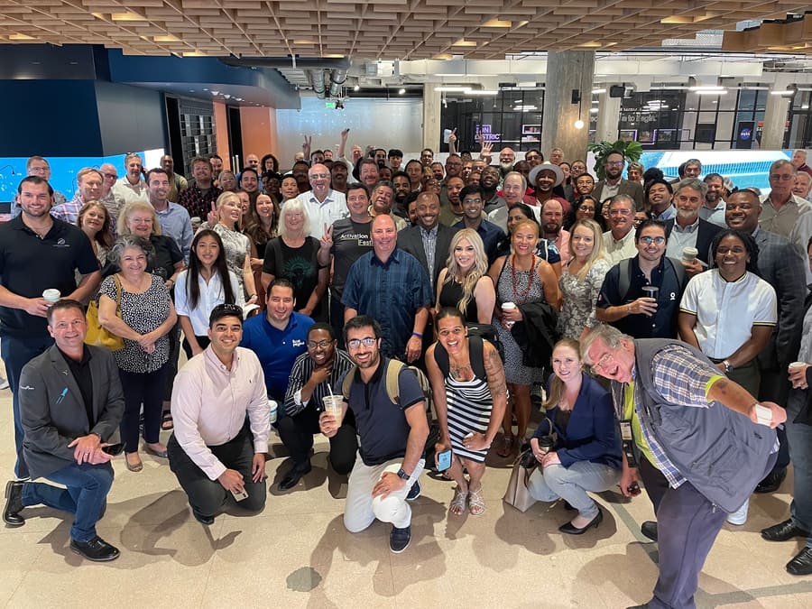 Grande grupo de dezenas de pessoas reunido em um espaço amplo e moderno