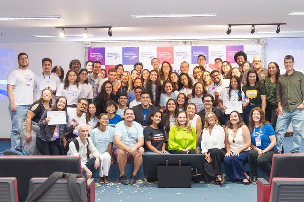 Turma comemorando com confete ao lado do palco de encerramento