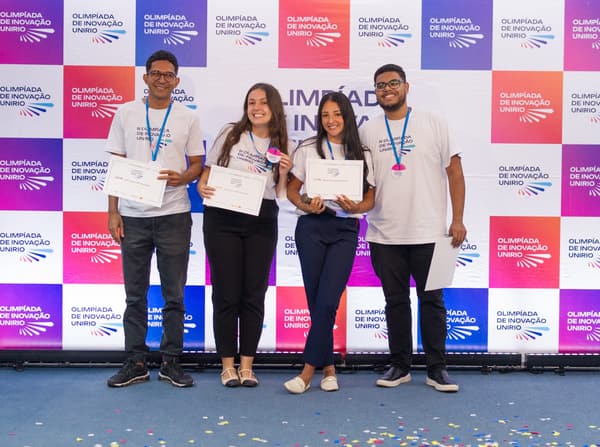 Equipe vencedora segurando os certificados de primeiro lugar
