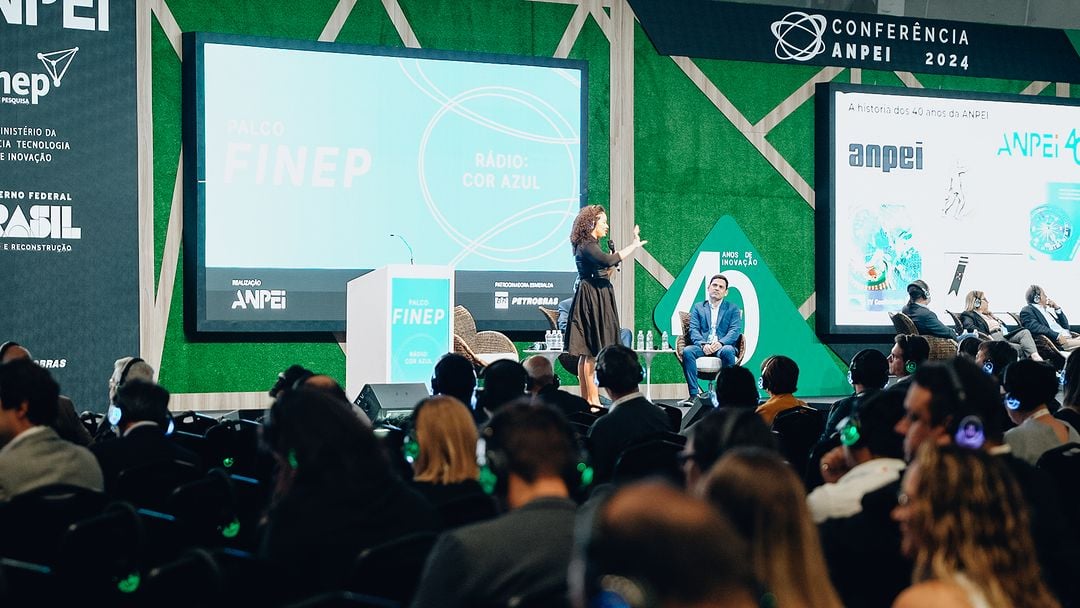 Auditório lotado durante a Conferência ANPEI 2024, com o telão da FINEP ao fundo do palco.